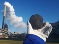 Piece of coal in front of power plant