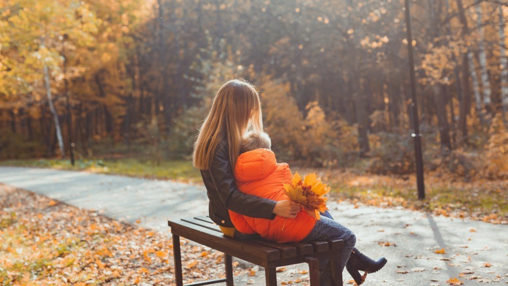 women sitting in bench with young boy