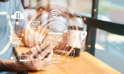 A persons hands holding a smartphone with various icons of technology, such as cloud, Wi-Fi signal, email envelope, shopping cart, location pin, and security lock floating around it. The image conveys the concept of modern connectivity.