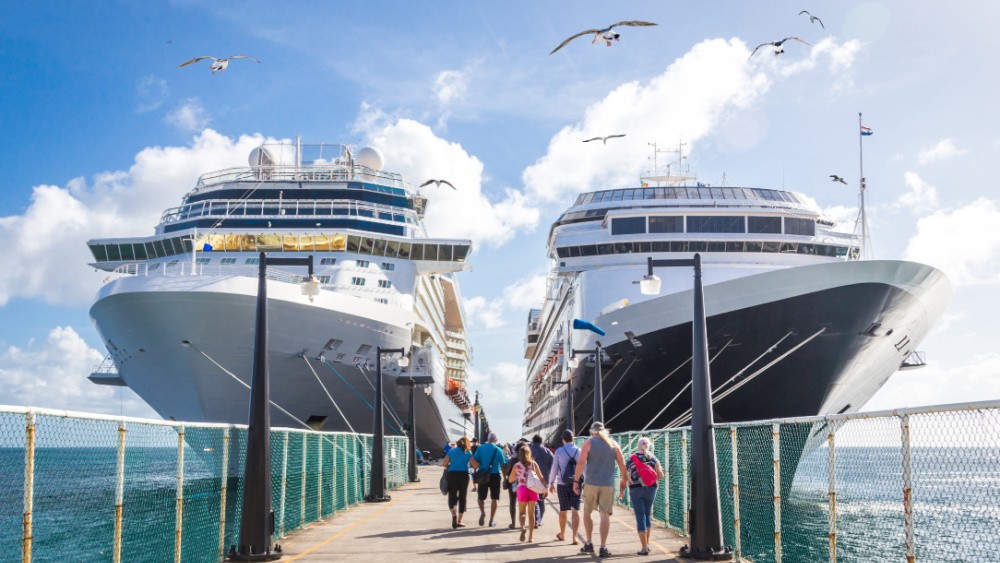 People getting on two cruise ships docked at the port.