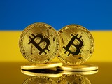 Bitcoin před ukrajinskou vlajkou – ilustrační obrázek k regulaci kryptoměn.
